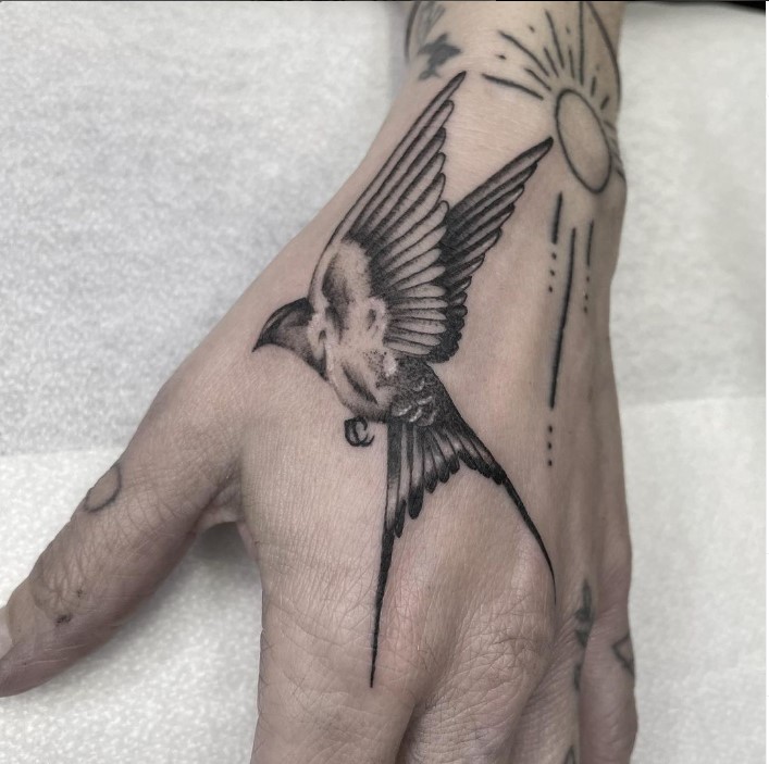 tatuaje de pajaro en mano
